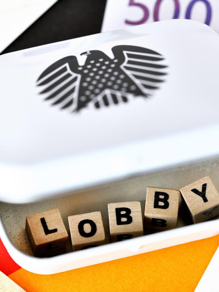 Buchstabenwürfel formen das Wort Lobby in einer Dose mit Bundesadler, Lobbyarbeit