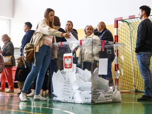 In einem Wahllokal in Krakau geben Menschen ihre Stimme ab: Parlamentswahlen in Polen 2023.