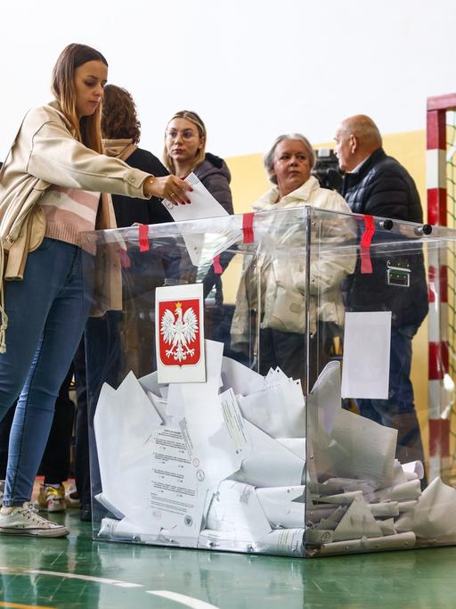 In einem Wahllokal in Krakau geben Menschen ihre Stimme ab: Parlamentswahlen in Polen 2023.