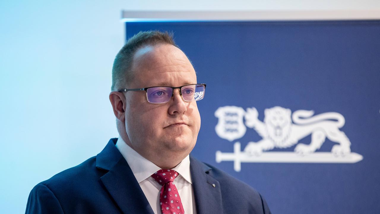 Estlands Geheimdienstchef Kaupo Rosin steht während einer Pressekonferenz in Tallinn 2025 vor einem Aufsteller mit Estlands Wappentier, einem Löwen.