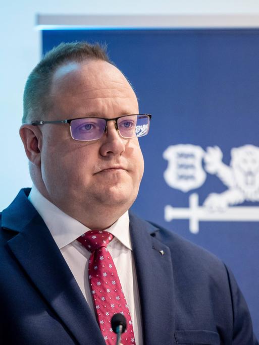 Estlands Geheimdienstchef Kaupo Rosin steht während einer Pressekonferenz in Tallinn 2025 vor einem Aufsteller mit Estlands Wappentier, einem Löwen.