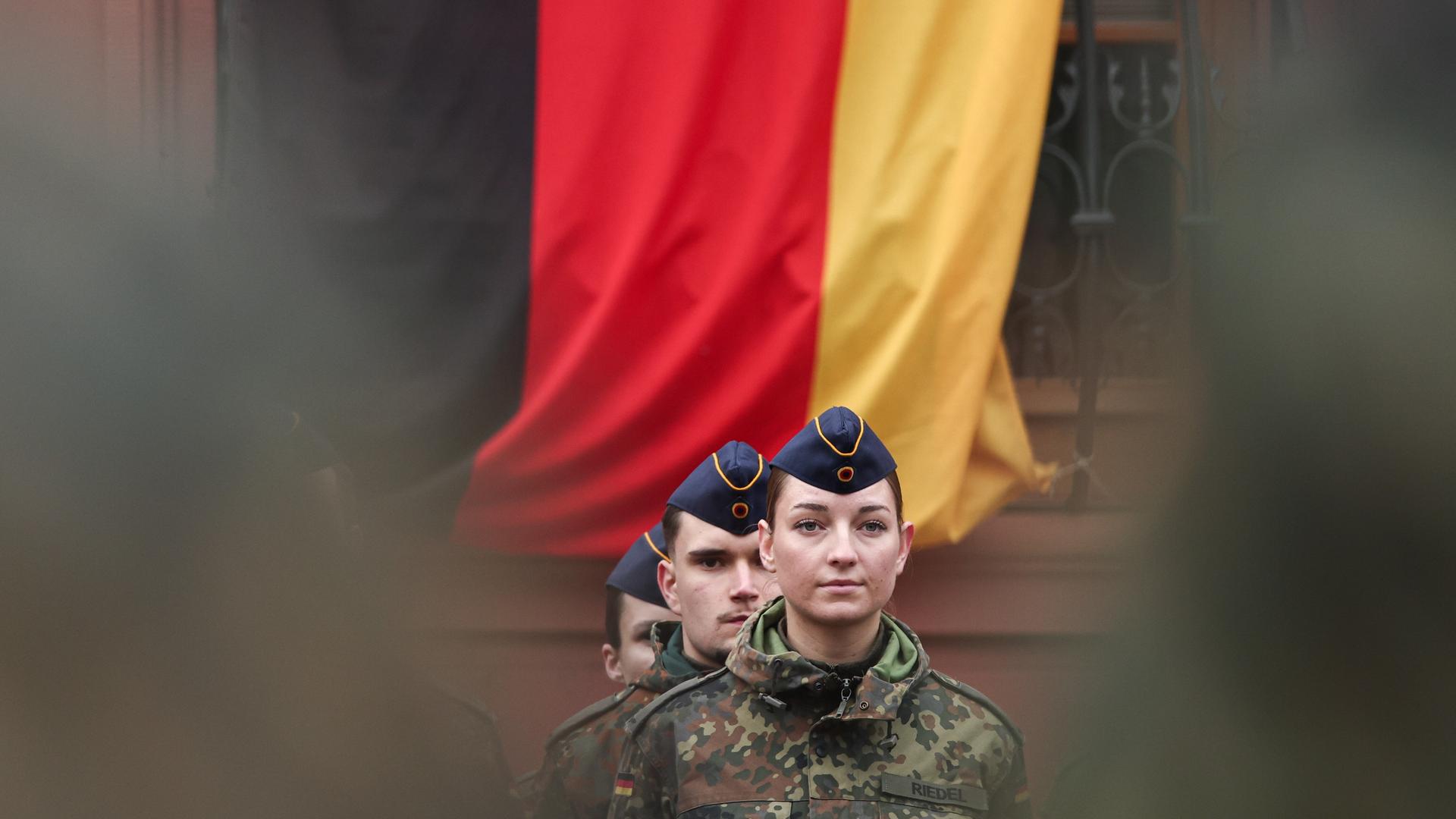 Eine Soldatin steht vor einer Deutschlandflagge. Rund 160 Rekrutinnen und Rekruten des Luftwaffenausbildungsbataillons aus Roth und des Heimatschutzregiments 5 aus Hessen mit Sitz in Thüringen legten ihren Diensteid ab.
