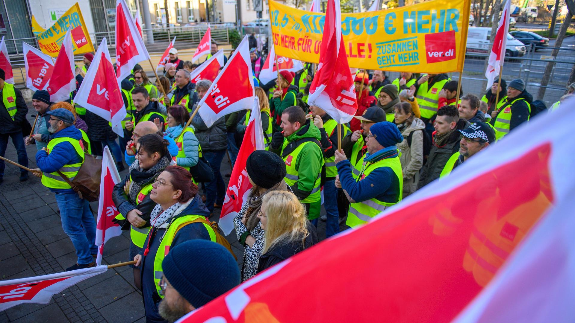 Streikende stehen mit Verdi-Fahnen vor der Gewerkschaftszentrale in Magdeburg. Streikende stehen mit Verdi-Fahnen vor der Gewerkschaftszentrale in Magdeburg.