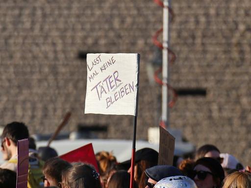 Bei einer Demo wird ein Schild mit der Aufschrift hochgehalten: "Lass mal keine Täter bleiben".