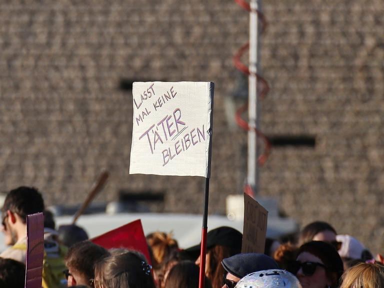 Bei einer Demo wird ein Schild mit der Aufschrift hochgehalten: "Lass mal keine Täter bleiben".