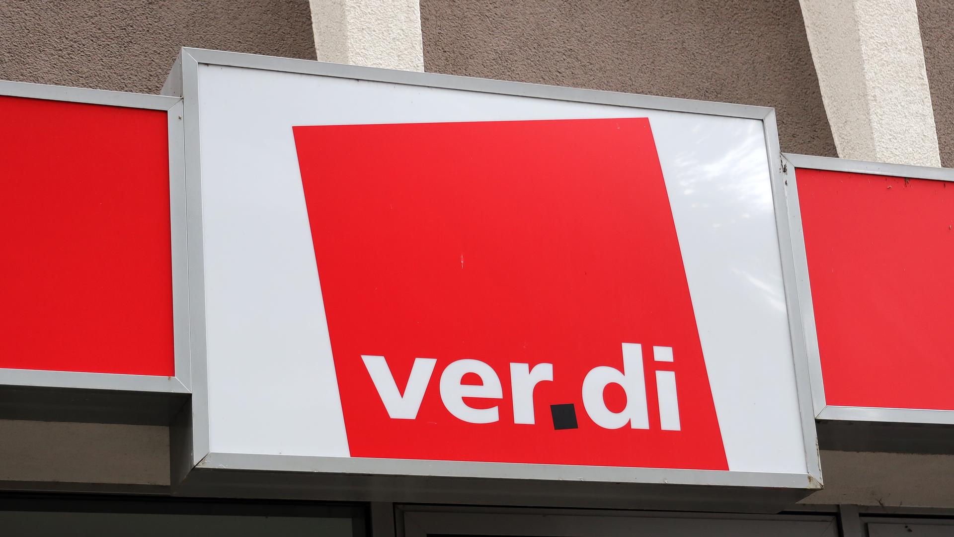 Das weiß-rote Logo von Verdi an einer Wand.