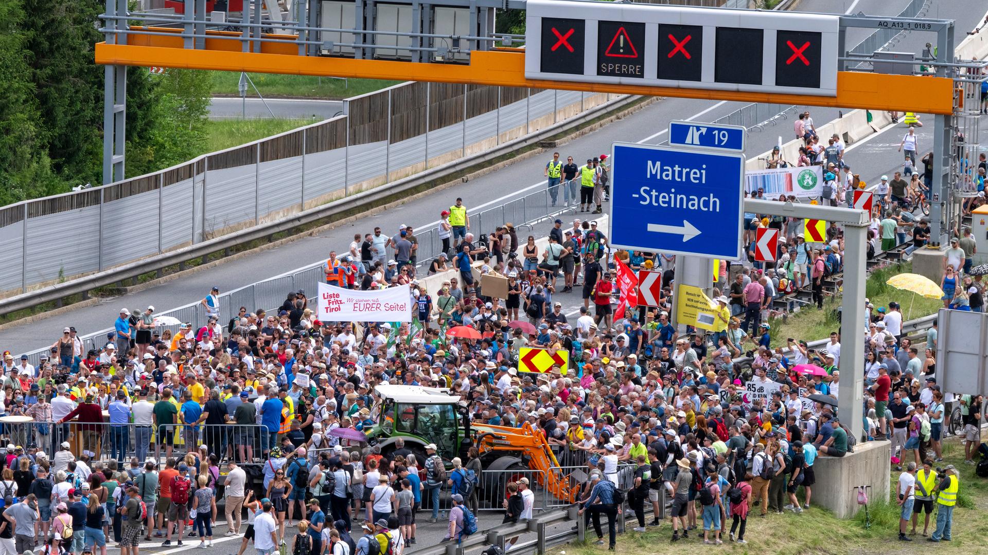 Zahlreiche Menschen demonstrieren auf der gesperrten Brennerautobahn.