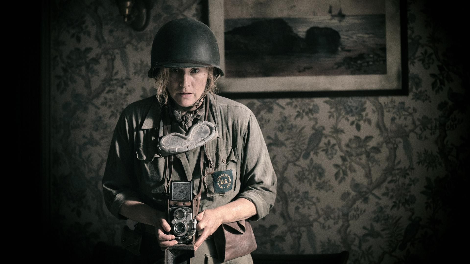 Kate Winslet mit Uniform und Kamera in einer Szene des Films "Die Fotografin".