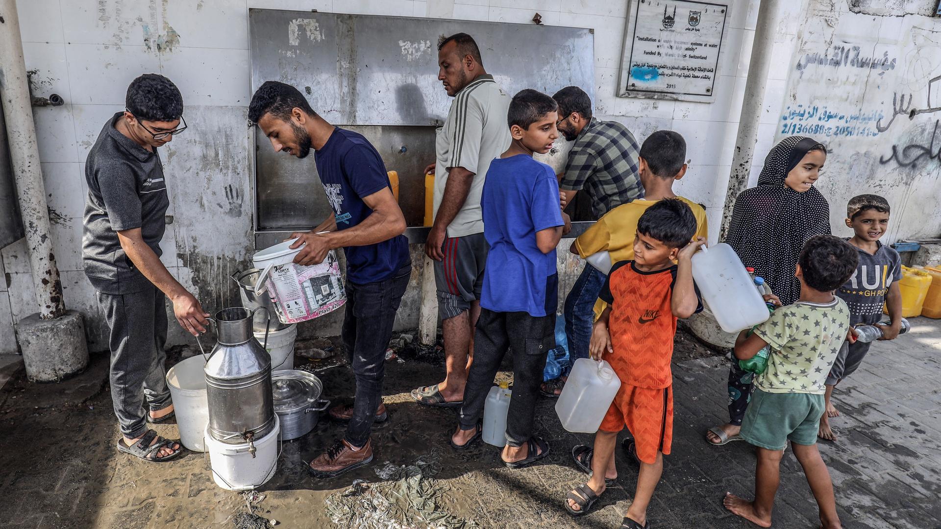 Palästinensische Gebiete, Khan Yunis: Palästinenser füllen Flaschen mit Trinkwasser aus einem Wasserhahn am Zentrum der Vereinten Nationen.