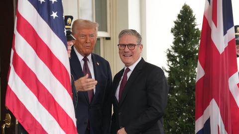 Großbritanniens Ministerpräsident Keir Starmer steht zusammen mit Donald Trump zwischen einer US-Flagge und dem Union Jack auf der Terasse des Weißen Hauses