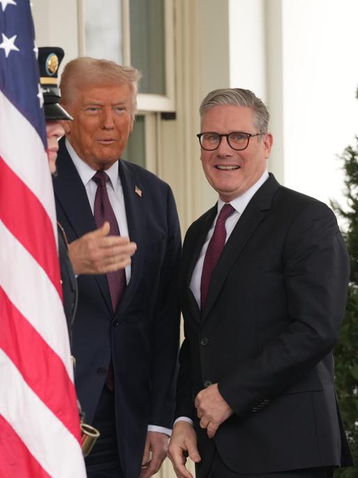 Großbritanniens Ministerpräsident Keir Starmer steht zusammen mit Donald Trump zwischen einer US-Flagge und dem Union Jack auf der Terasse des Weißen Hauses
