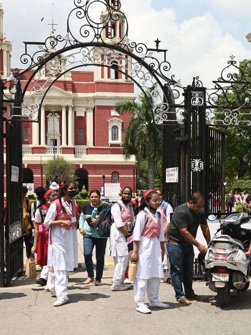 Schülerinnen und Schüler vor einer Schule in Neu-Dehli. 