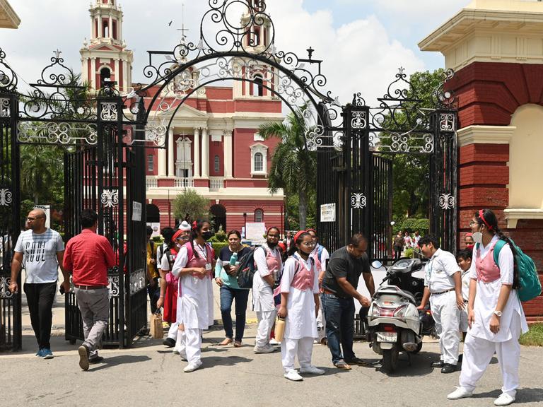 Schülerinnen und Schüler vor einer Schule in Neu-Dehli. 