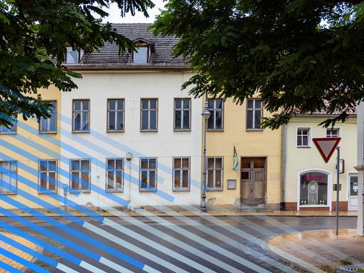Blick auf eine Straßenzeile mit Häusern deren Scheiben zum Teil eingeschlagen sind. Blick auf eine Straßenzeile mit Häusern deren Scheiben zum Teil eingeschlagen sind.