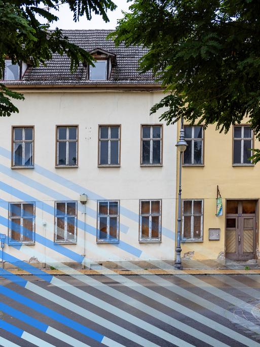 Blick auf eine Straßenzeile mit Häusern deren Scheiben zum Teil eingeschlagen sind. Blick auf eine Straßenzeile mit Häusern deren Scheiben zum Teil eingeschlagen sind.