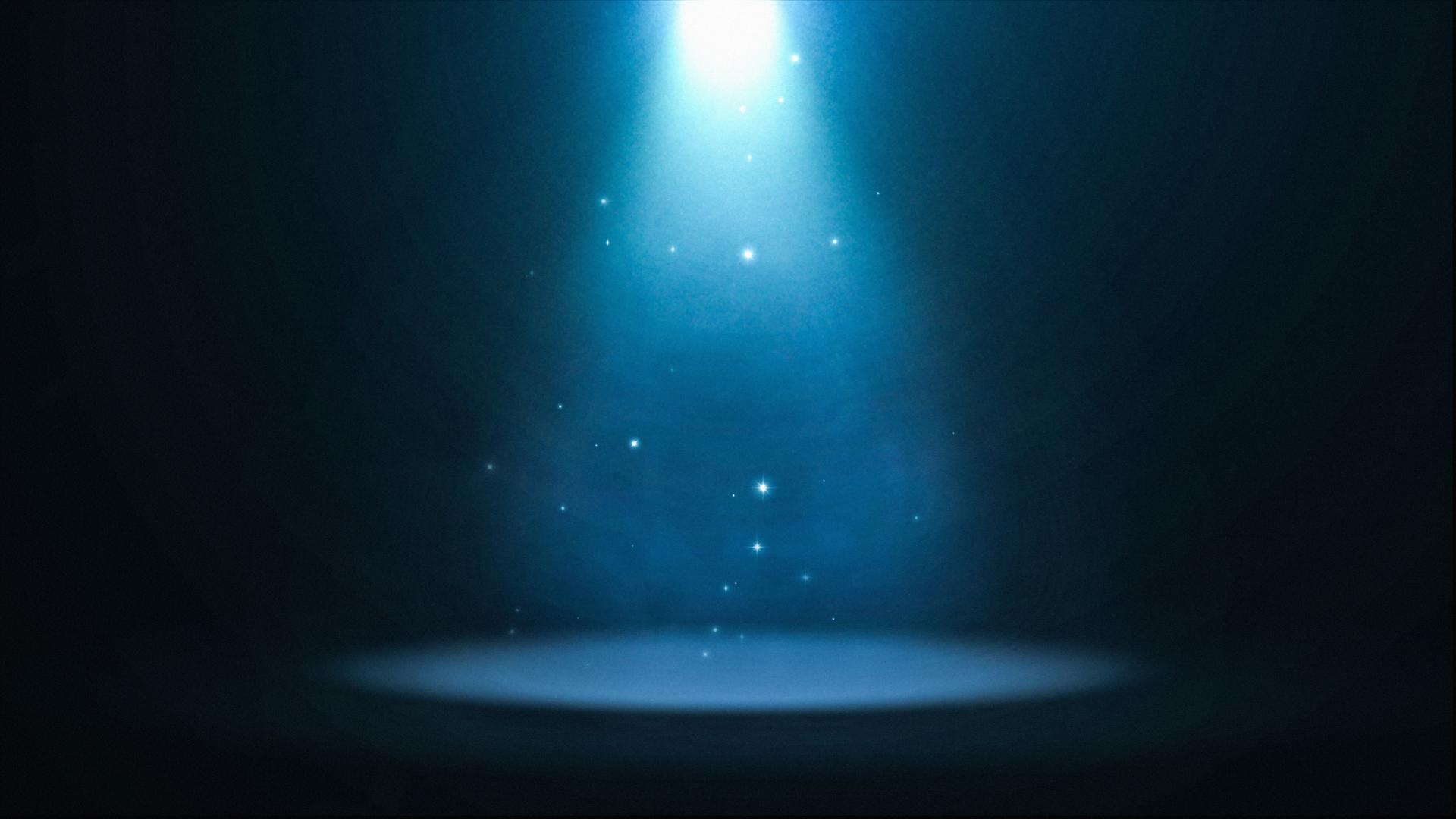 Ein bläulich strahlendes Spotlight ist auf eine leere Bühne gerichtet. Ein bläulich strahlendes Spotlight ist auf eine leere Bühne gerichtet.