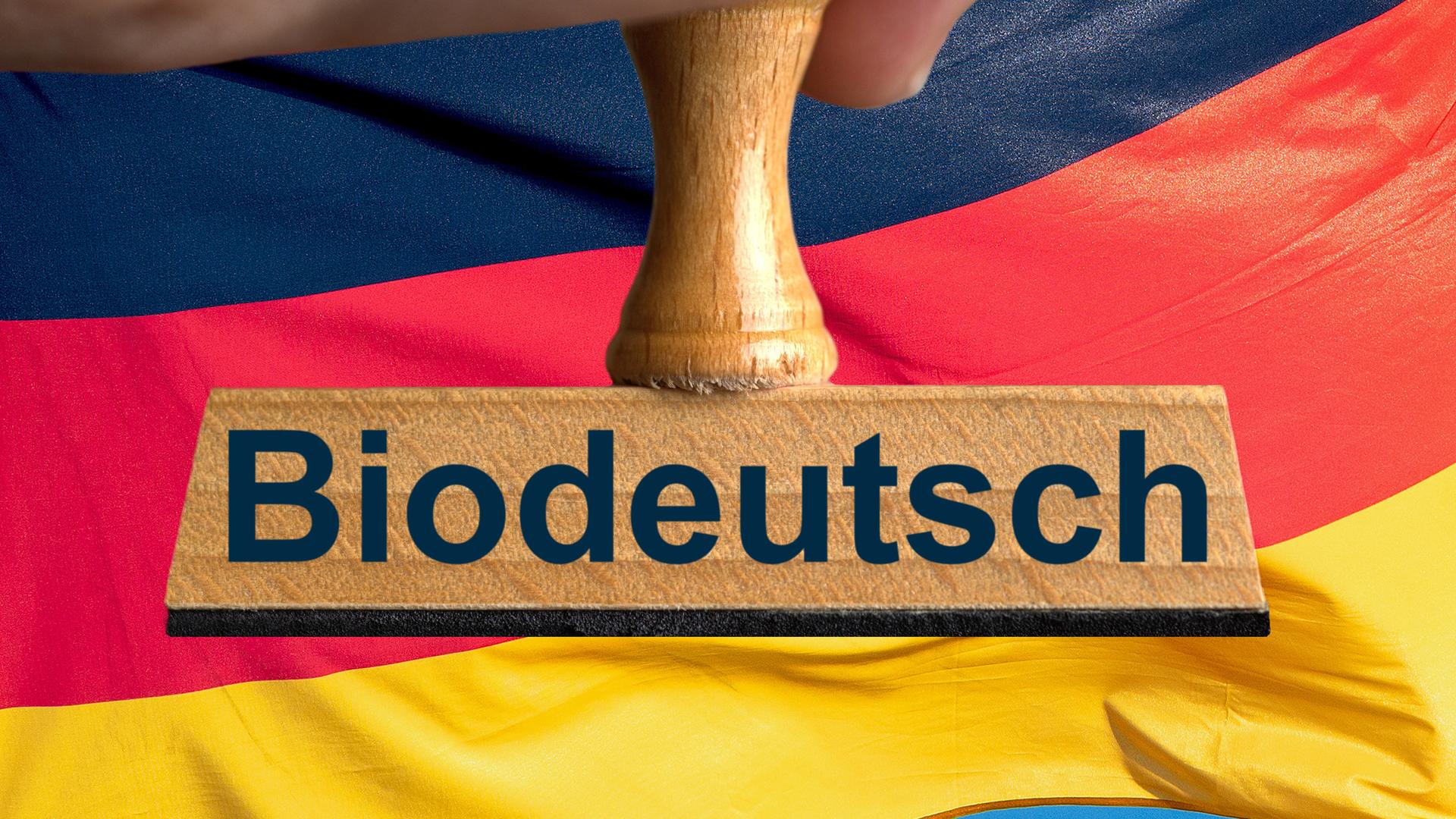 Das Foto zeigt eine Hand, die einen Stempel festhält. Auf dem Stempel steht "Biodeutsch". Das Wort "Biodeutsch" ist das Unwort vom Jahr 2024.