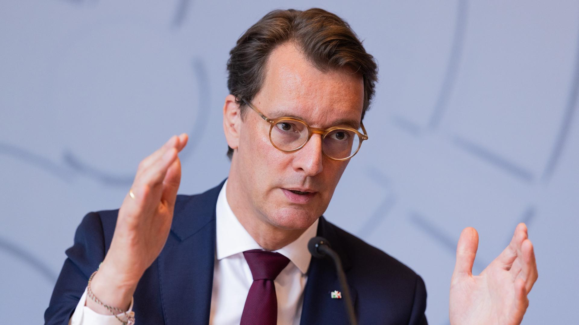 Das Bild zeigt Hendrik Wüst bei einem Statement, das er mit beiden Händen gestikulierend unterstreicht.
