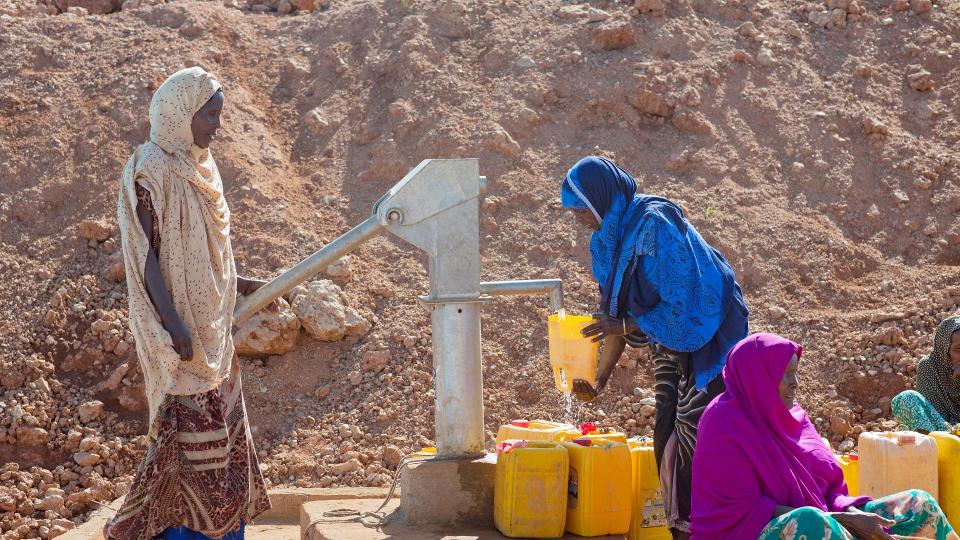 Frauen befüllen gelbe Wasserkanister an einer Wasserpumpe in Äthiopien.