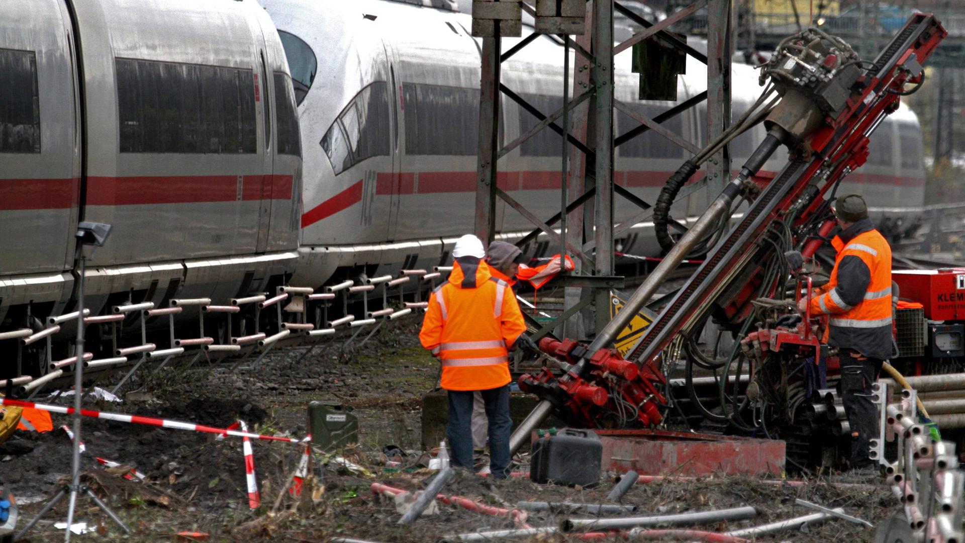 Gleisarbeiter stehen an der Eisenbahntrasse zur Feststellung möglicher Schäden im Bereich des Hauptbahnhofs.