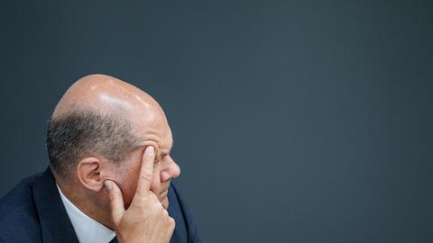 Bundeskanzler Olaf Scholz hat sein Gesicht nachdenklich in seine Hände gestützt und verfolgt eine Debatte im Bundestag. Bundeskanzler Olaf Scholz hat sein Gesicht nachdenklich in seine Hände gestützt und verfolgt eine Debatte im Bundestag.