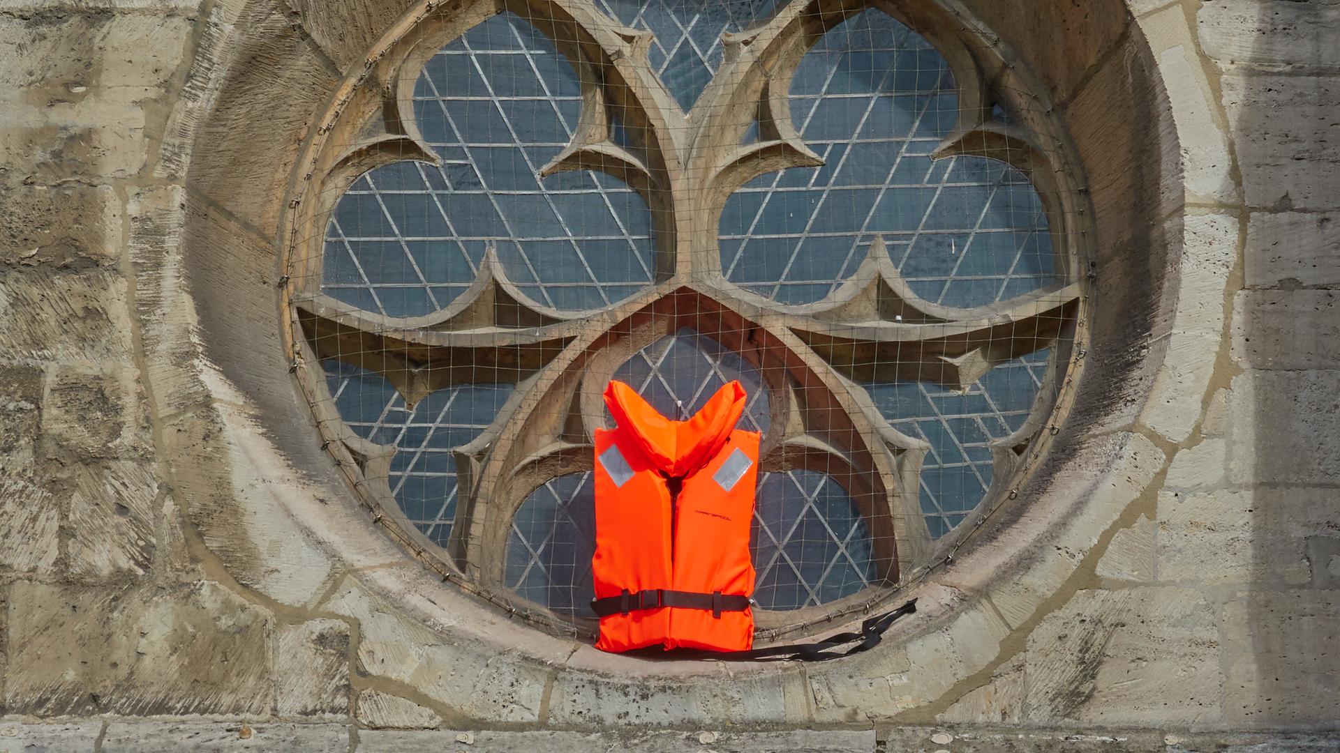 Eine Rettungsweste wird in einem Fenster der Kathedrale In Braunschweig gezeigt,  als Unterstützung für Flüchtlinge.