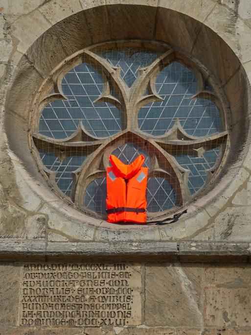 Eine Rettungsweste wird in einem Fenster der Kathedrale In Braunschweig gezeigt,  als Unterstützung für Flüchtlinge.