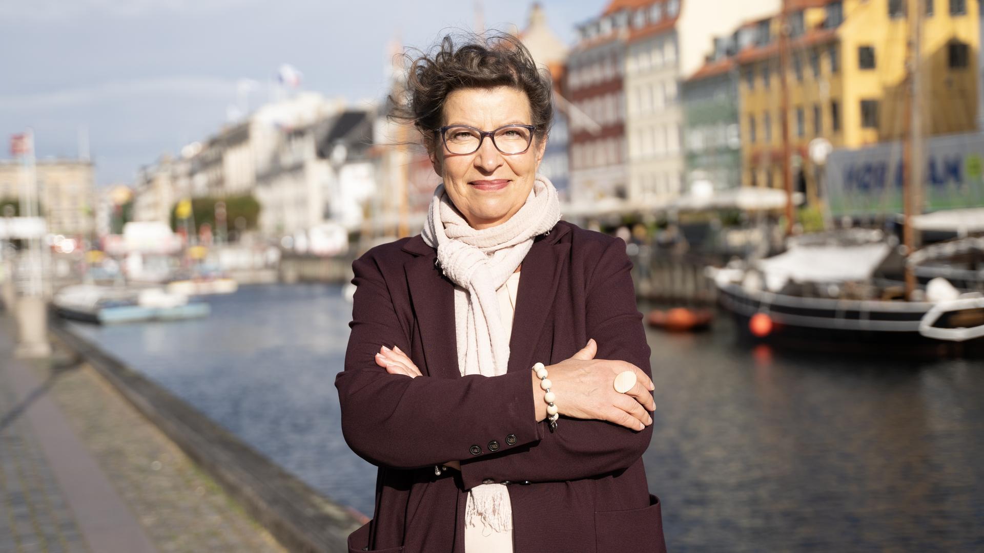 Die Exekutivdirektorin der Europäischen Umweltagentur (EEA), Leena Ylä-Mononen, steht mit verschränkten Armen vor einem Kanal und lächelt. Die Exekutivdirektorin der Europäischen Umweltagentur (EEA), Leena Ylä-Mononen, steht mit verschränkten Armen vor einem Kanal und lächelt.