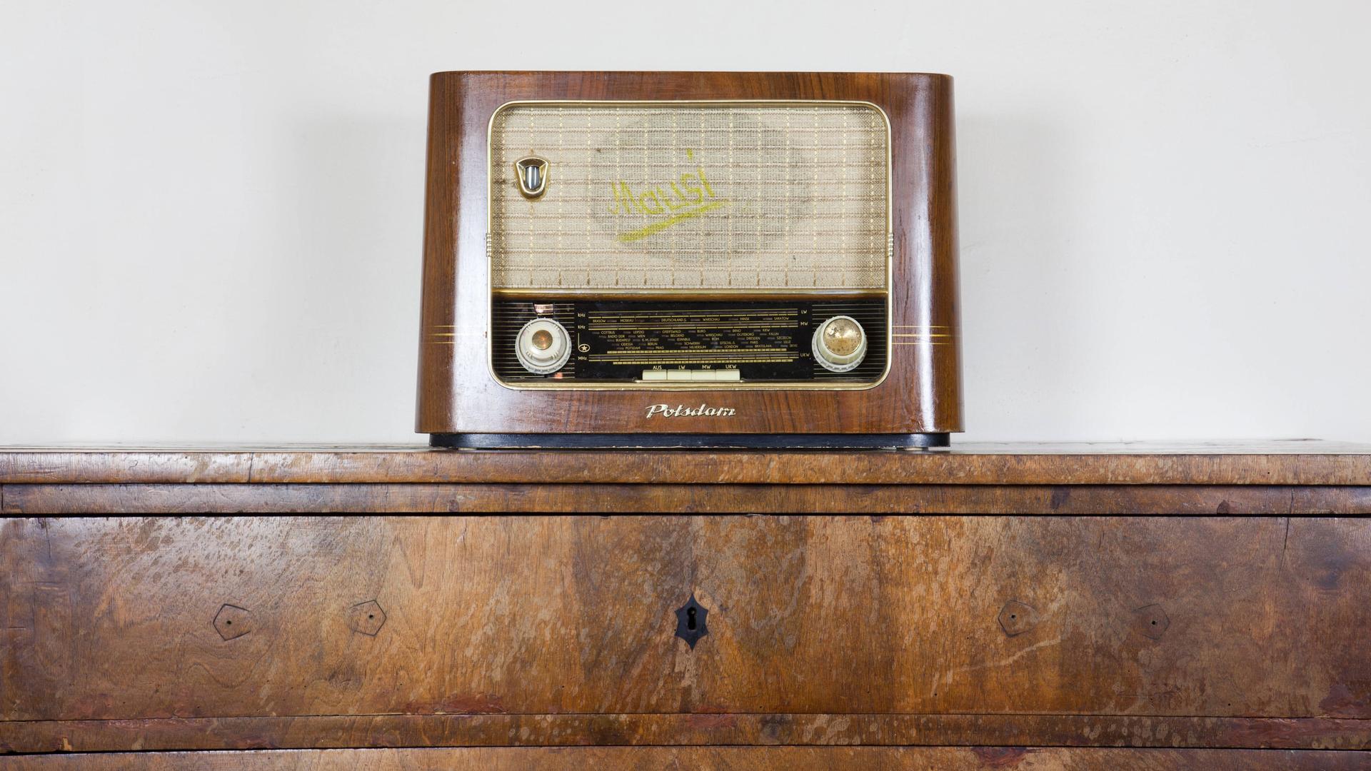 Altes Röhrenradio auf einer Holzkommode.