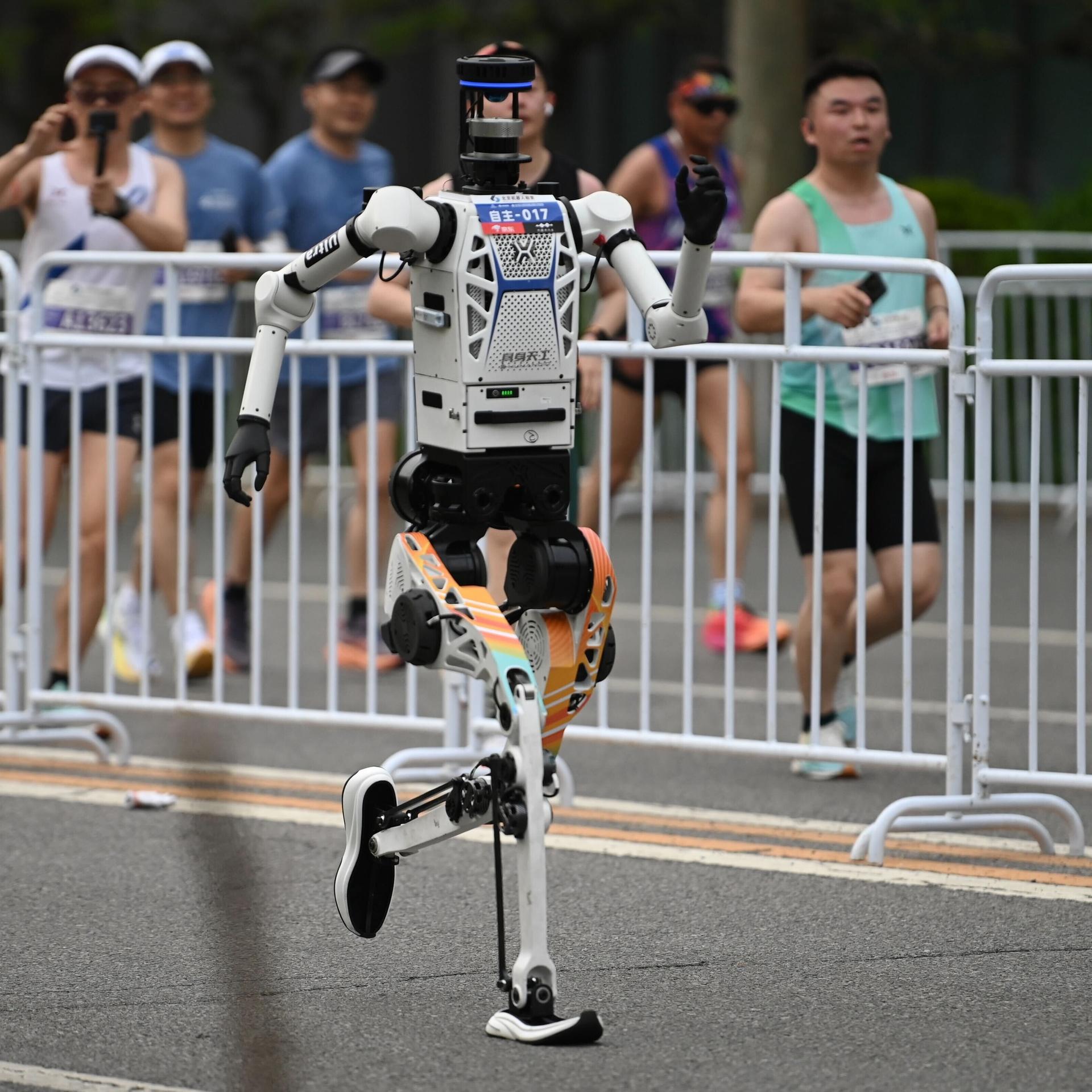 Zu sehen ist ein Roboter in Peking. Er läuft auf einer abgesperrten Strecke.