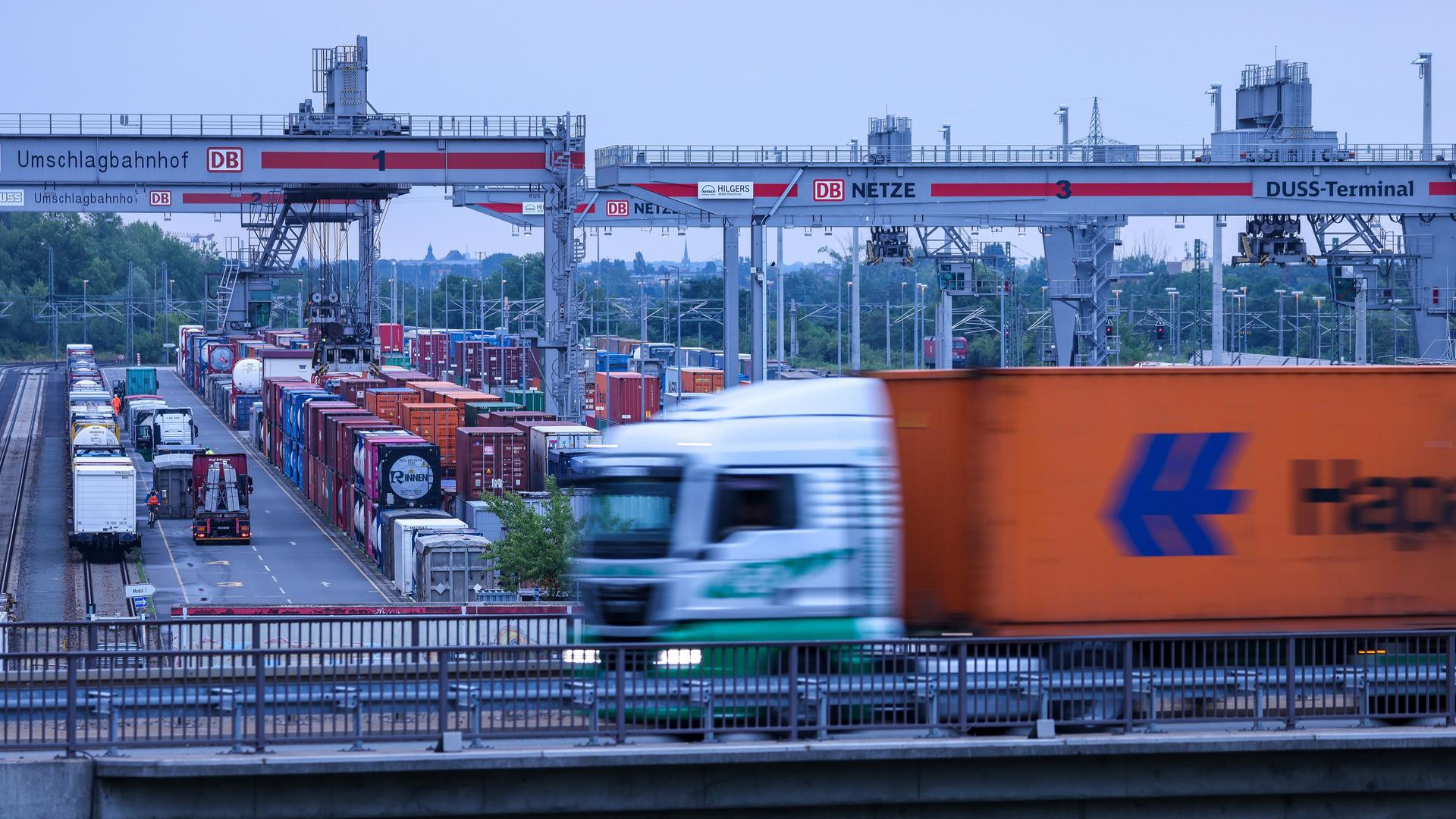 Ein Lkw fährt über das Gelände des Umschlagbahnhofs Leipzig-Wahren. Im Hintergrund stehen mehrere Container.