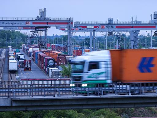 Ein Lkw fährt über das Gelände des Umschlagbahnhofs Leipzig-Wahren. Im Hintergrund stehen mehrere Container.