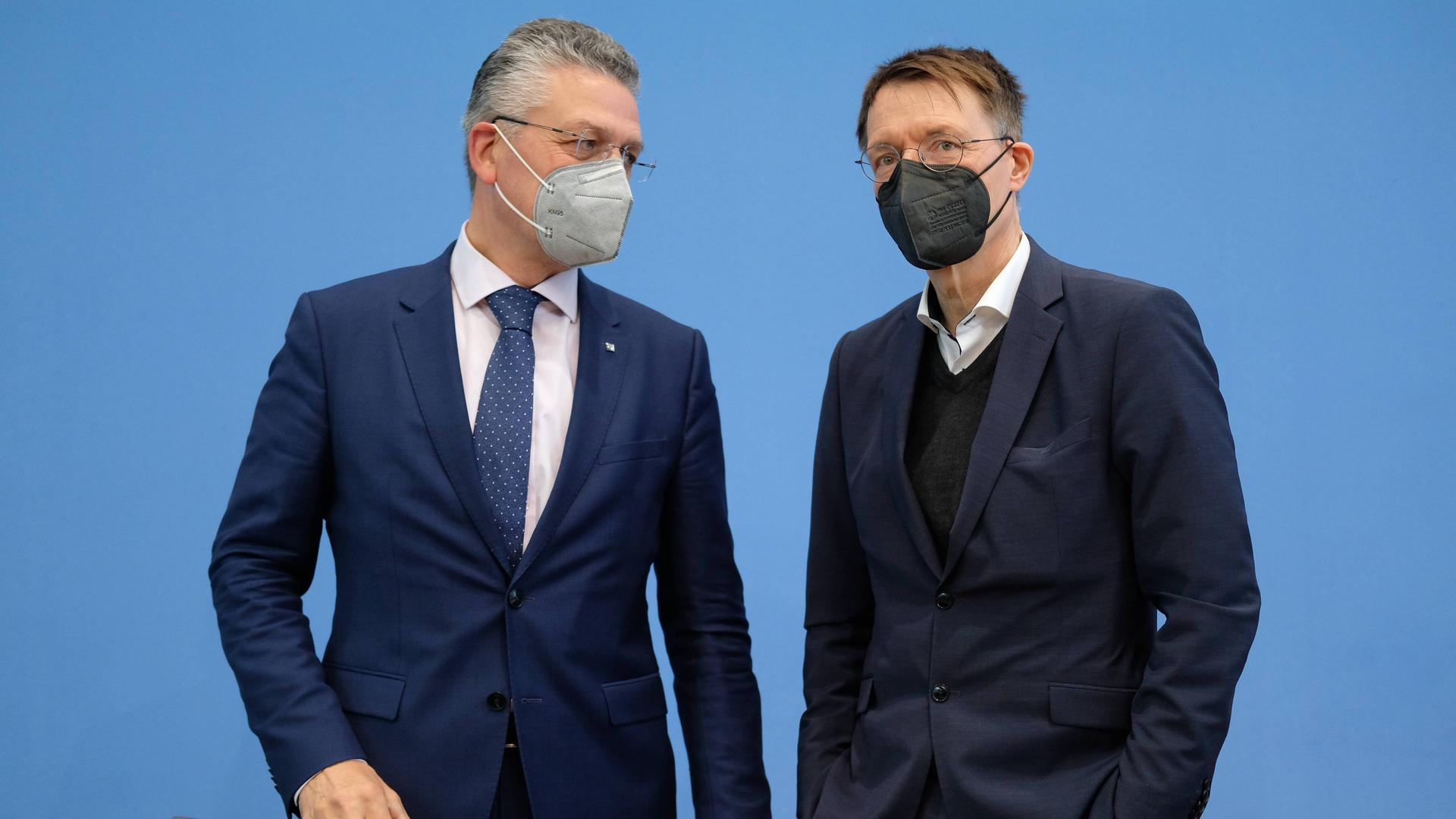 Bei einer Pressekonferenz im Jahr 2022 stehen der damalige Präsident des Robert-Koch-Instituts Lothar H. Wieler zusammen mit Bundesgesundheitsminister Karl Lauterbach (SPD) zusammen und unterhalten sich. Beide tragen FFP2-Masken.