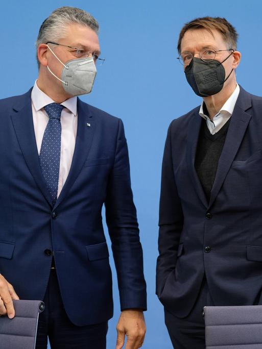 Bei einer Pressekonferenz im Jahr 2022 stehen der damalige Präsident des Robert-Koch-Instituts Lothar H. Wieler zusammen mit Bundesgesundheitsminister Karl Lauterbach (SPD) zusammen und unterhalten sich. Beide tragen FFP2-Masken.