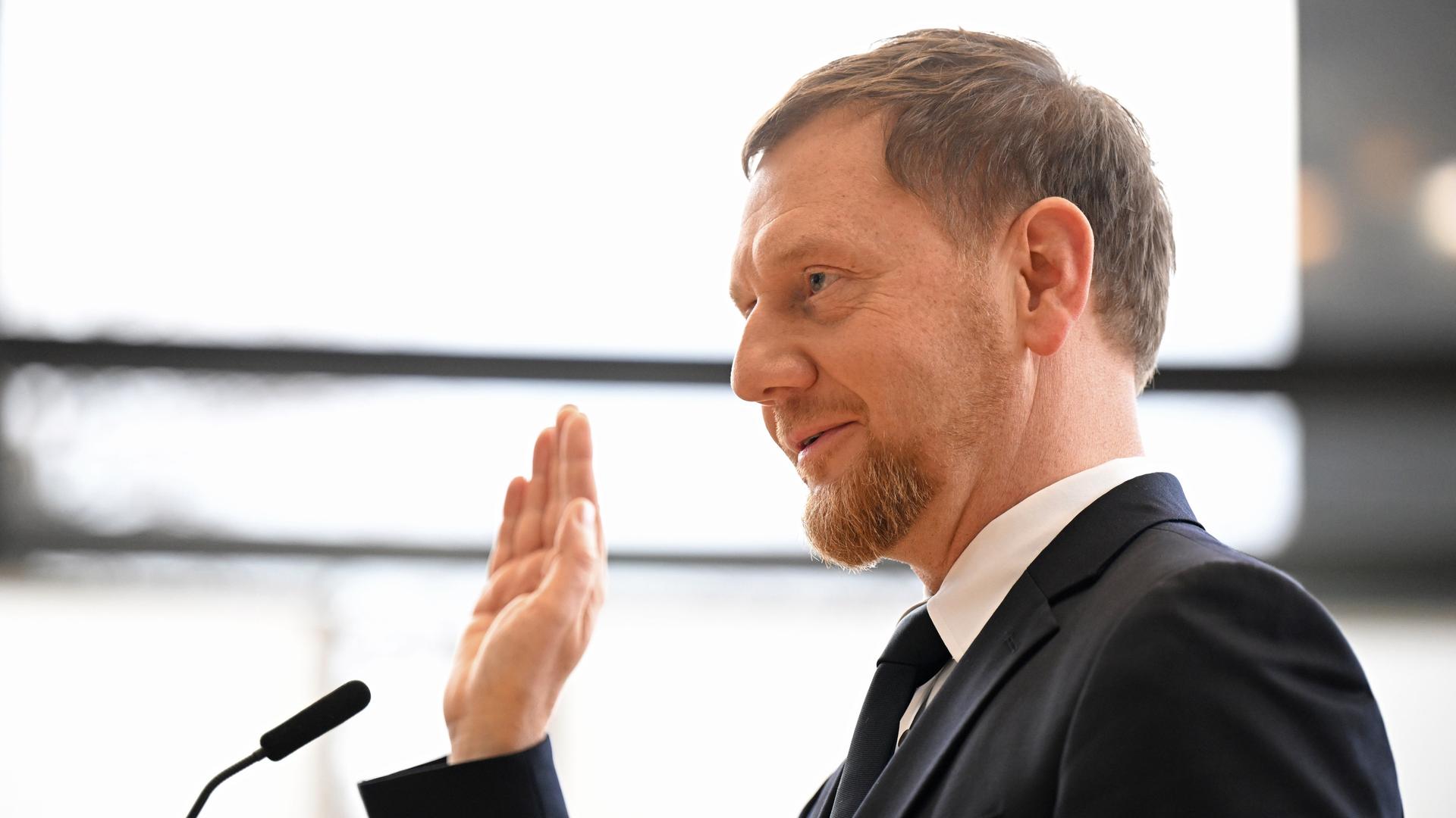 Michael Kretschmer (CDU) legt nach der Wahl zum Ministerpräsidenten von Sachsen im Plenarsaal im Sächsischen Landtag dem Amtseid ab. Er hat eine Hand zum Schwören gehoben.