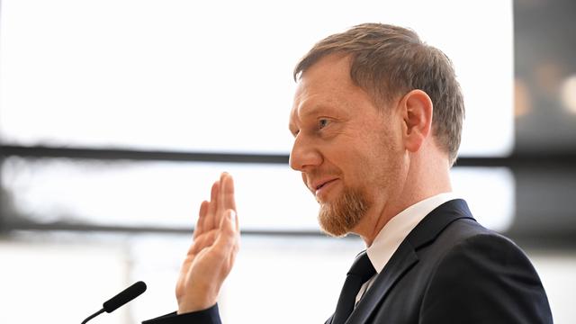 Michael Kretschmer (CDU) legt nach der Wahl zum Minister-Präsidenten von dem Bundes-Land Sachsen im Plenarsaal im Sächsischen Landtag den Amts-Eid ab. Er hat eine Hand zum Schwur erhoben.