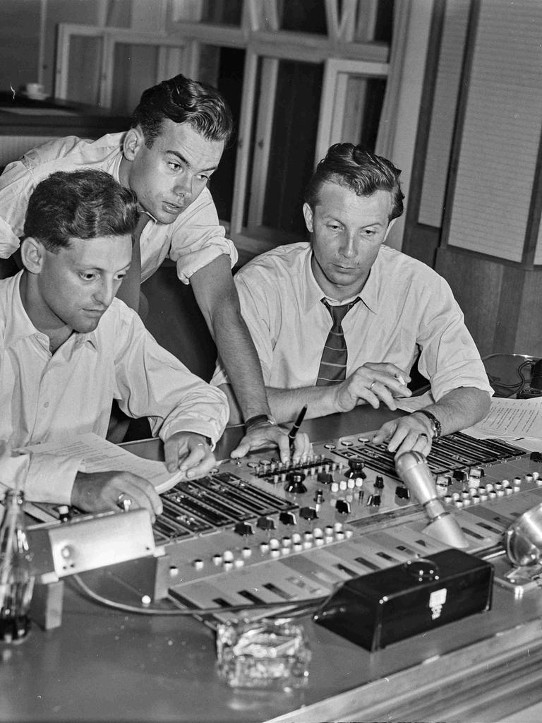 Schwarz-weiß Aufnahme von drei jungen Männern vor einem Mischpult in einem Studio in den 60er-Jahren.