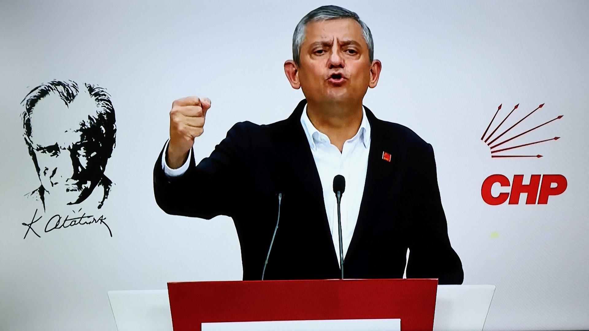Özel steht hinter einem Redepult und spricht. Er hat eine Hand zur Faust geballt. Auf der Wand hinter ihm steht der Schriftzug "CHP".