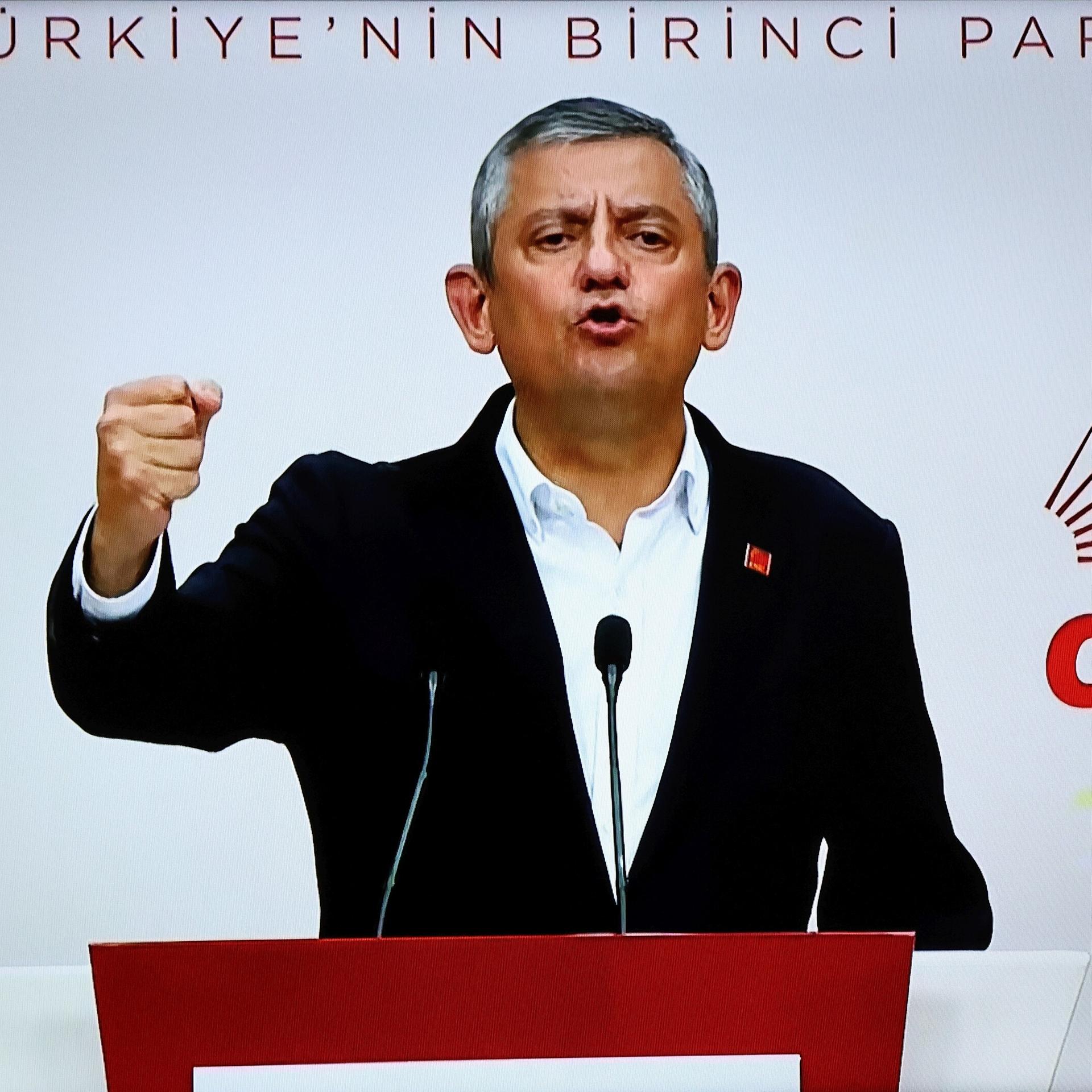 Özel steht hinter einem Redepult und spricht. Er hat eine Hand zur Faust geballt. Auf der Wand hinter ihm steht der Schriftzug "CHP".