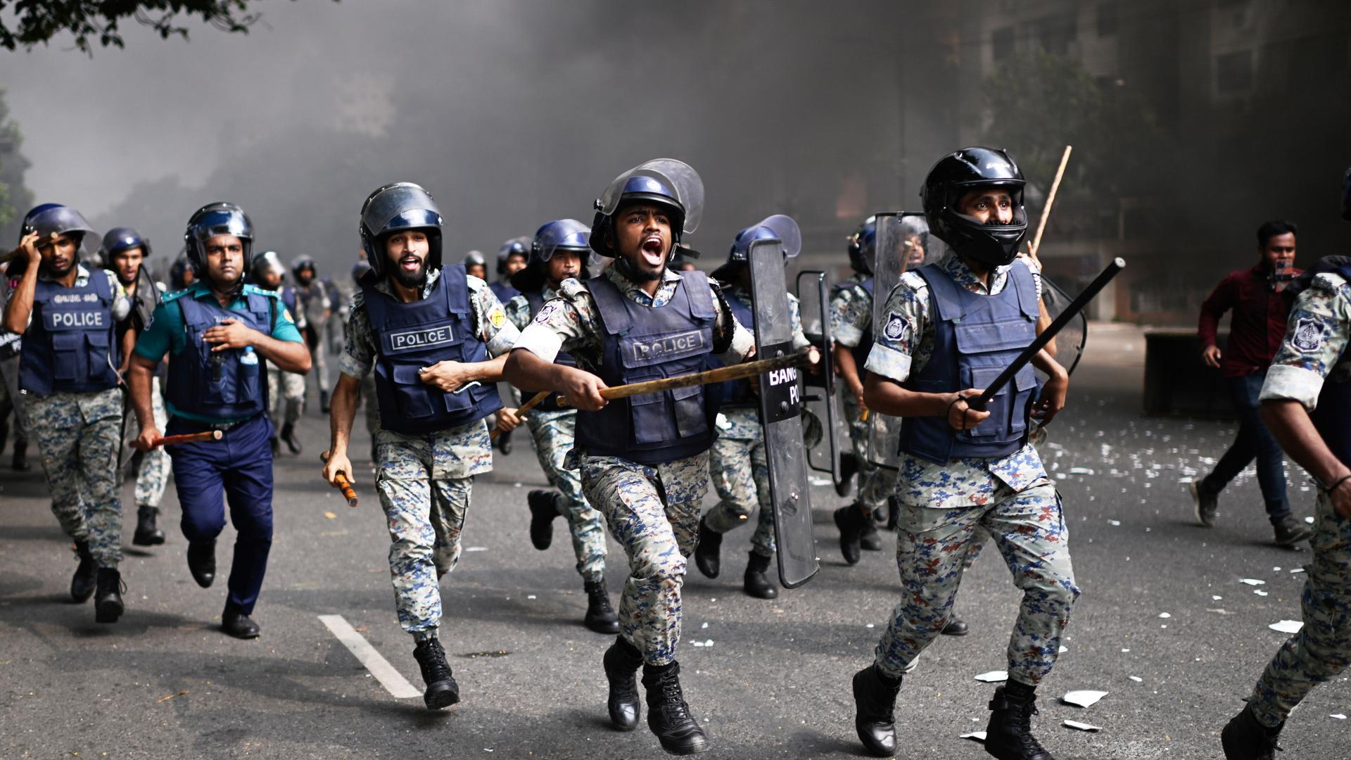Polizisten vertreiben Demonstranten vor dem Parlamentsgebäude in Dhaka. Polizisten vertreiben Demonstranten vor dem Parlamentsgebäude in Dhaka.