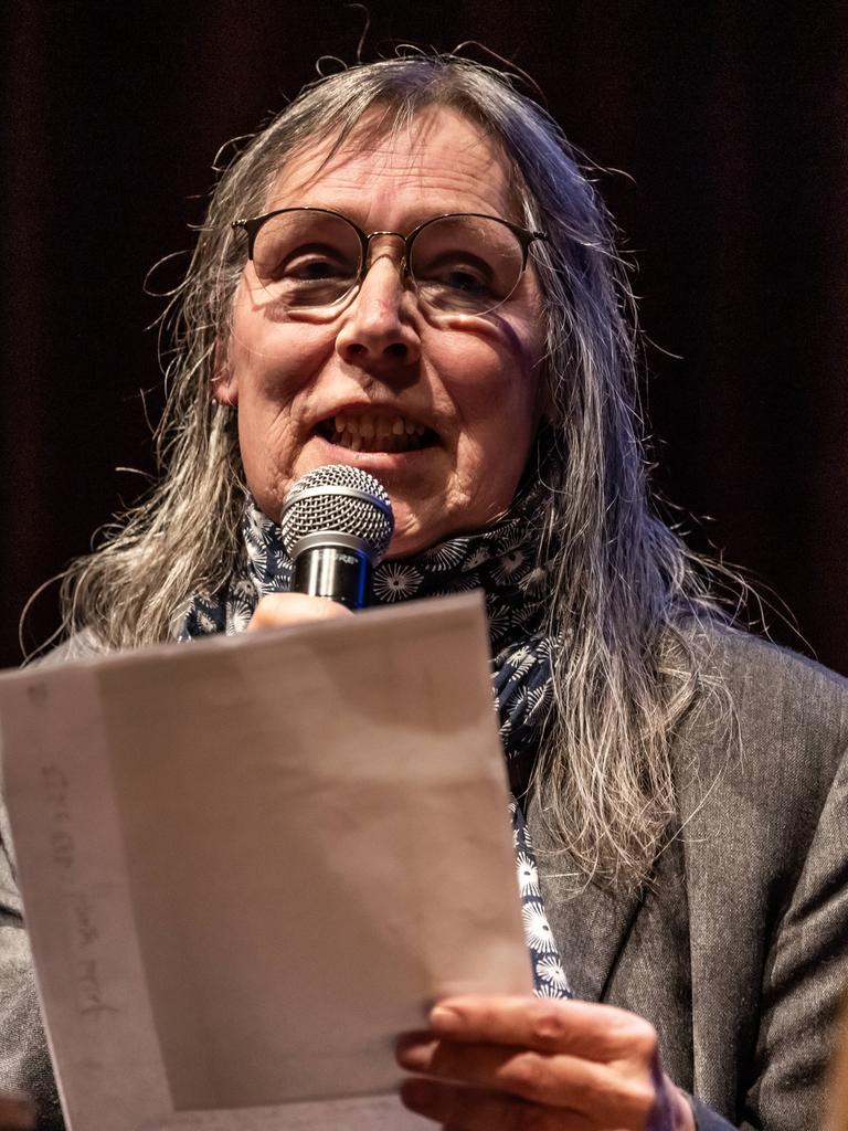 Jayne-Ann Igel liest in der Volksbühne am Rosa-Luxemburg-Platz. Sie sitzt vor einem Mikrofon und hält Zettel in der Hand.