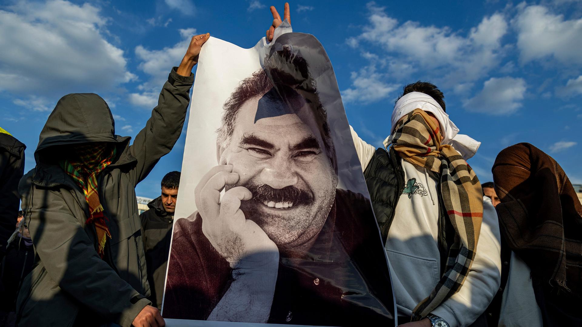 Verhüllte Männer halten ein Porträt von Abdullah Ocalan in die Höhe Verhüllte Männer halten ein Porträt von Abdullah Ocalan in die Höhe