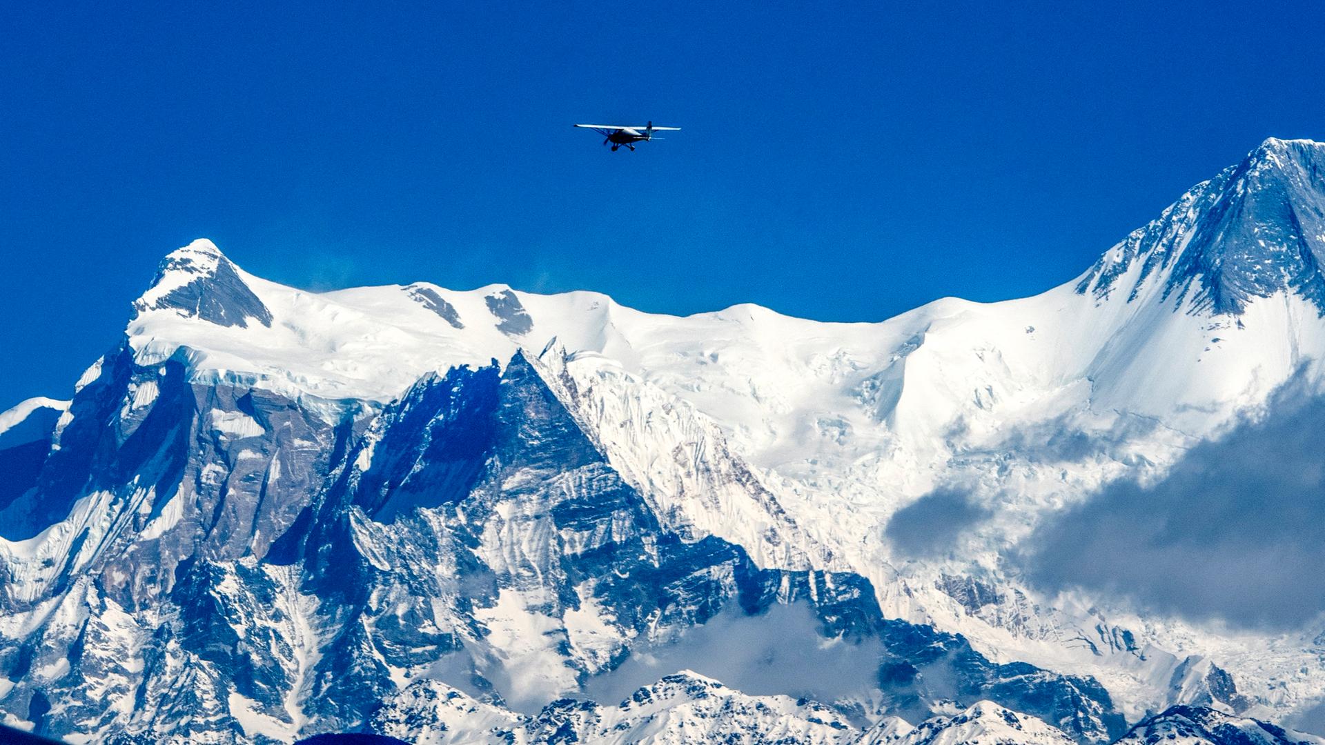 Das Massiv Annapurna im Himalaya, darüber fliegt ein Helikopter. Das Massiv Annapurna im Himalaya, darüber fliegt ein Helikopter.