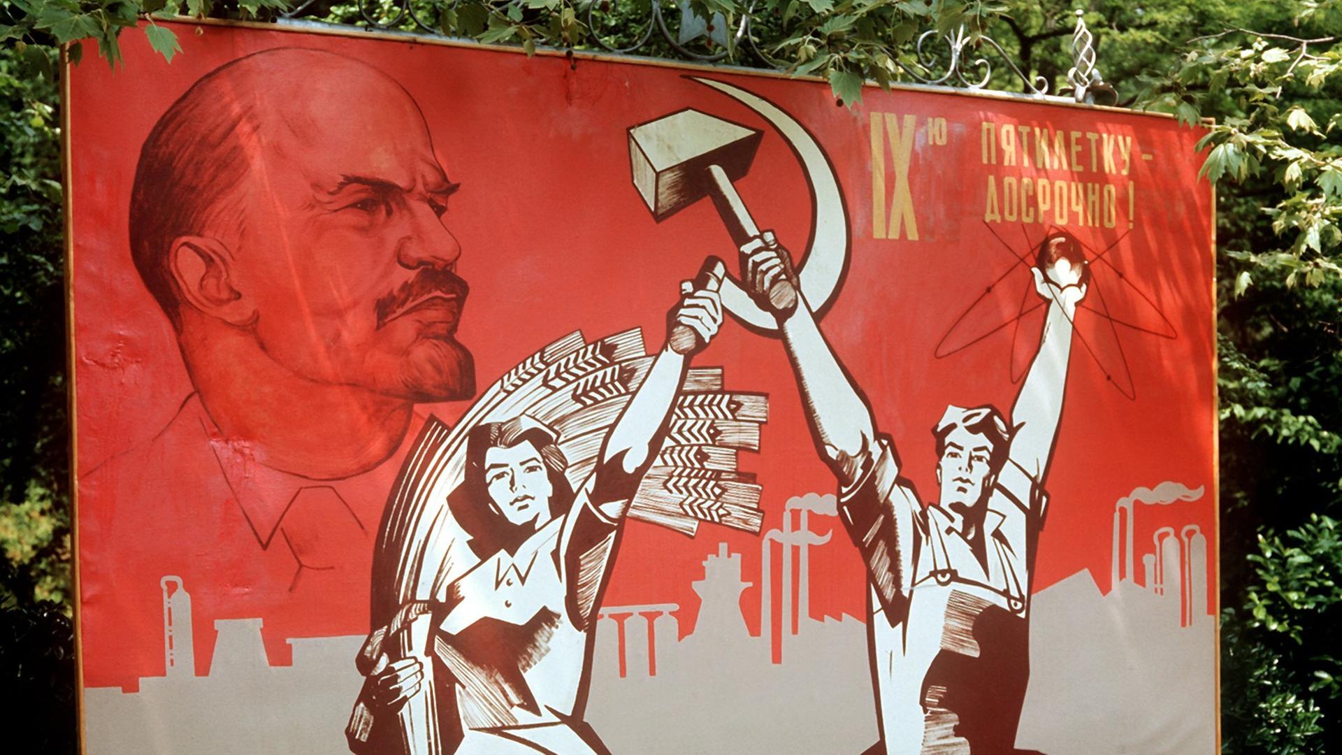 Ein großformatiges Plakat mit Lenin-Konterfei und der Darstellung von Arbeiter und Bäuerin mit Hammer und Sichel