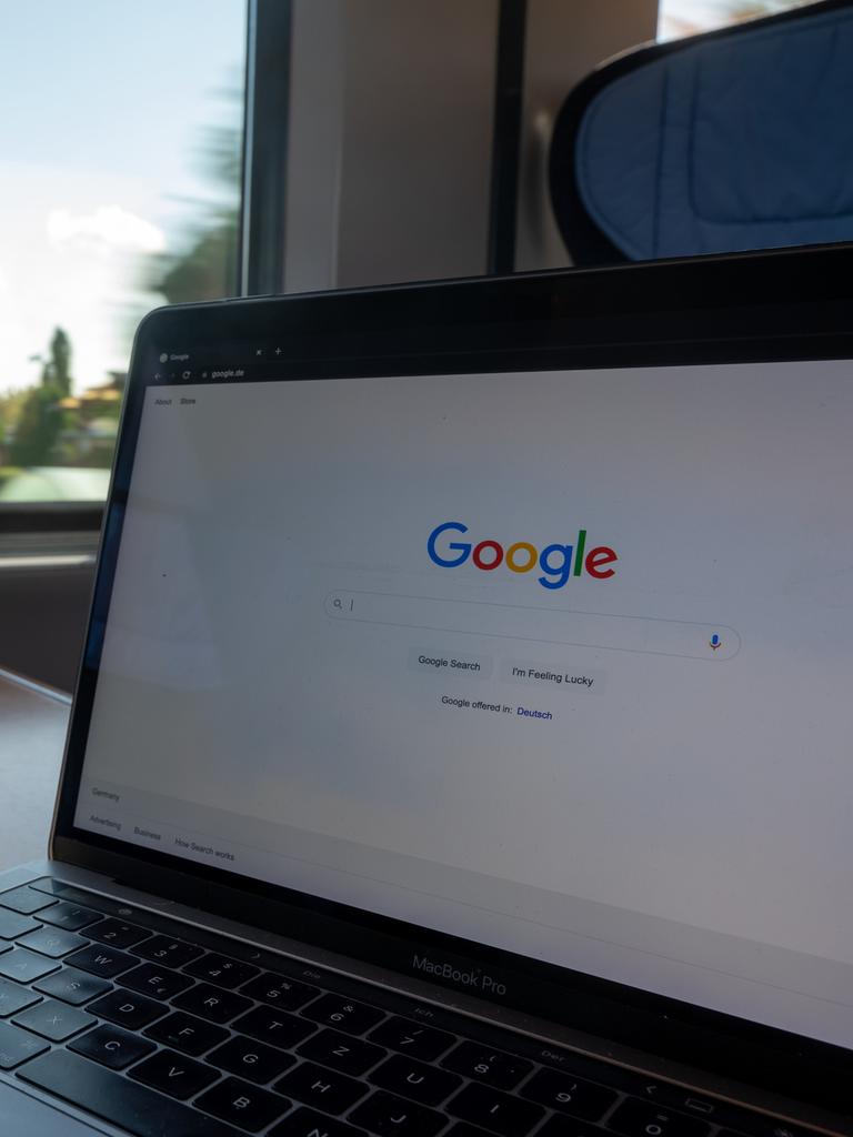 In einem Zug steht ein Laptop mit der Google-Homepage auf einem Tisch.