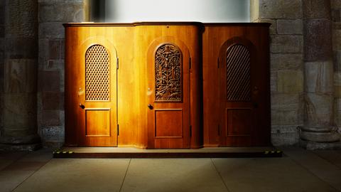 Ein Beichtstuhl in einer Kirche der von der Sonne gestreift wird