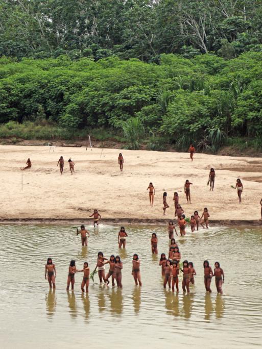 Im Juni 2024 stehen Mitglieder des unkontaktierten Volkes der Mashco Piro am Las Piedras Fluss im peruanischen Amazonas Regenwald.