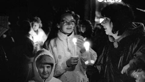 Frauen mit Kindern und Kerzen gehen zu einer Demonstration