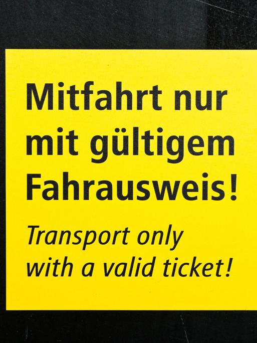Auf einem Schild an einer Bahn steht "Mitfahrt nur mit gültigem Fahrausweis!"