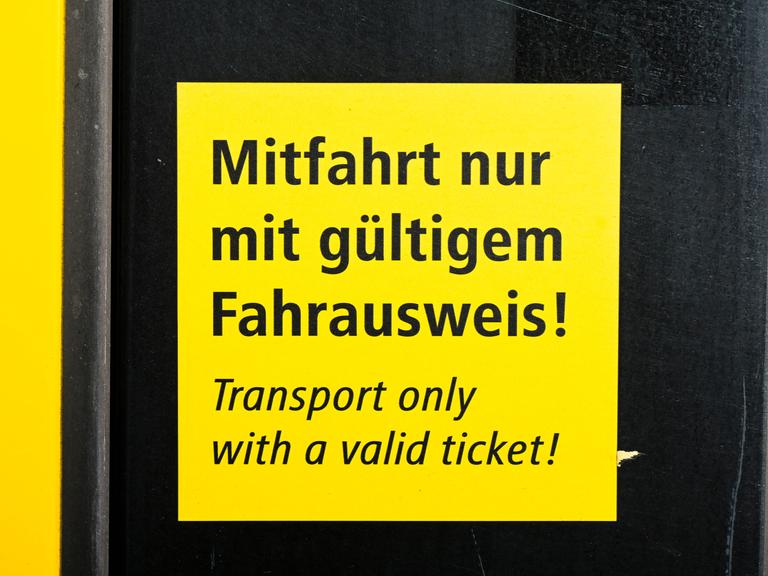 Auf einem Schild an einer Bahn steht "Mitfahrt nur mit gültigem Fahrausweis!"